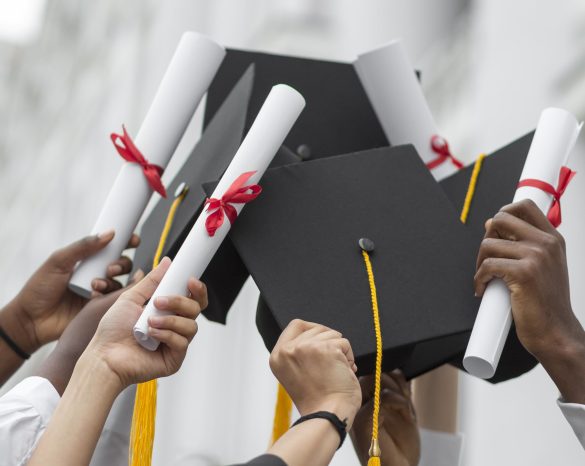 close-up-hands-holding-diplomas-caps close-up-hands-holding-diplomas-caps